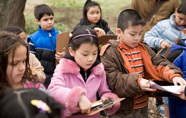 Group of kids outside with clipboards