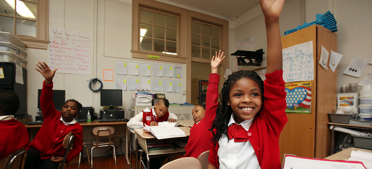 Kids raising hands in classroom