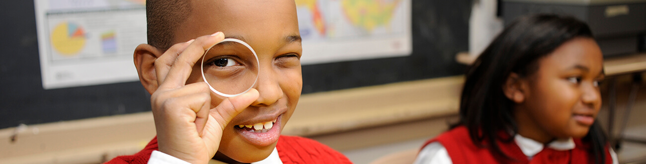 Young kids looking through magnifying glass