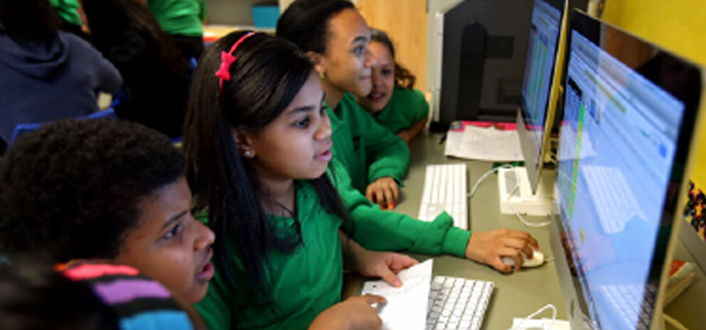 Kids in front of computer screens learning