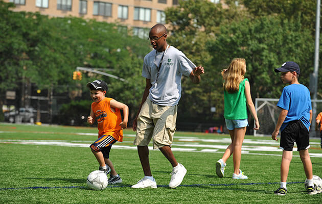 Kids and coach playing soccer